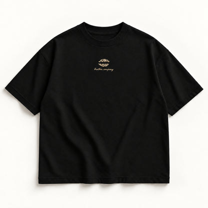 Schwarzes More Alive Tee, Vorderseite mit kleinem JURONOID-Stick in Champagner auf der Brust