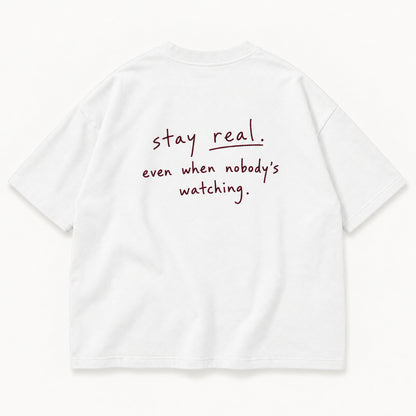 Weißes Stay Real Tee, Rücken mit „stay real. even when nobody’s watching.“ in feinem Merlot-Stick
