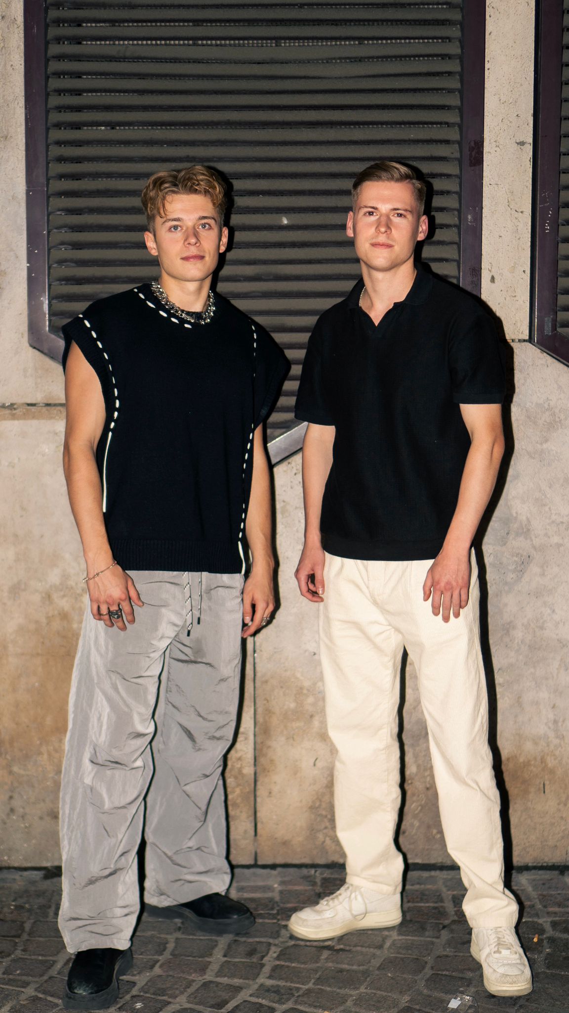 Die Brüder Robin und Julian Gössele, Gründer von JURONOID und JUPRO, vor einem dunklen Rollladen