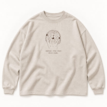 Beiges JURONOID Handle With Care Longsleeve von vorne mit brauner Hand-Gehirn-Liniengrafik und kleinem Schriftzug