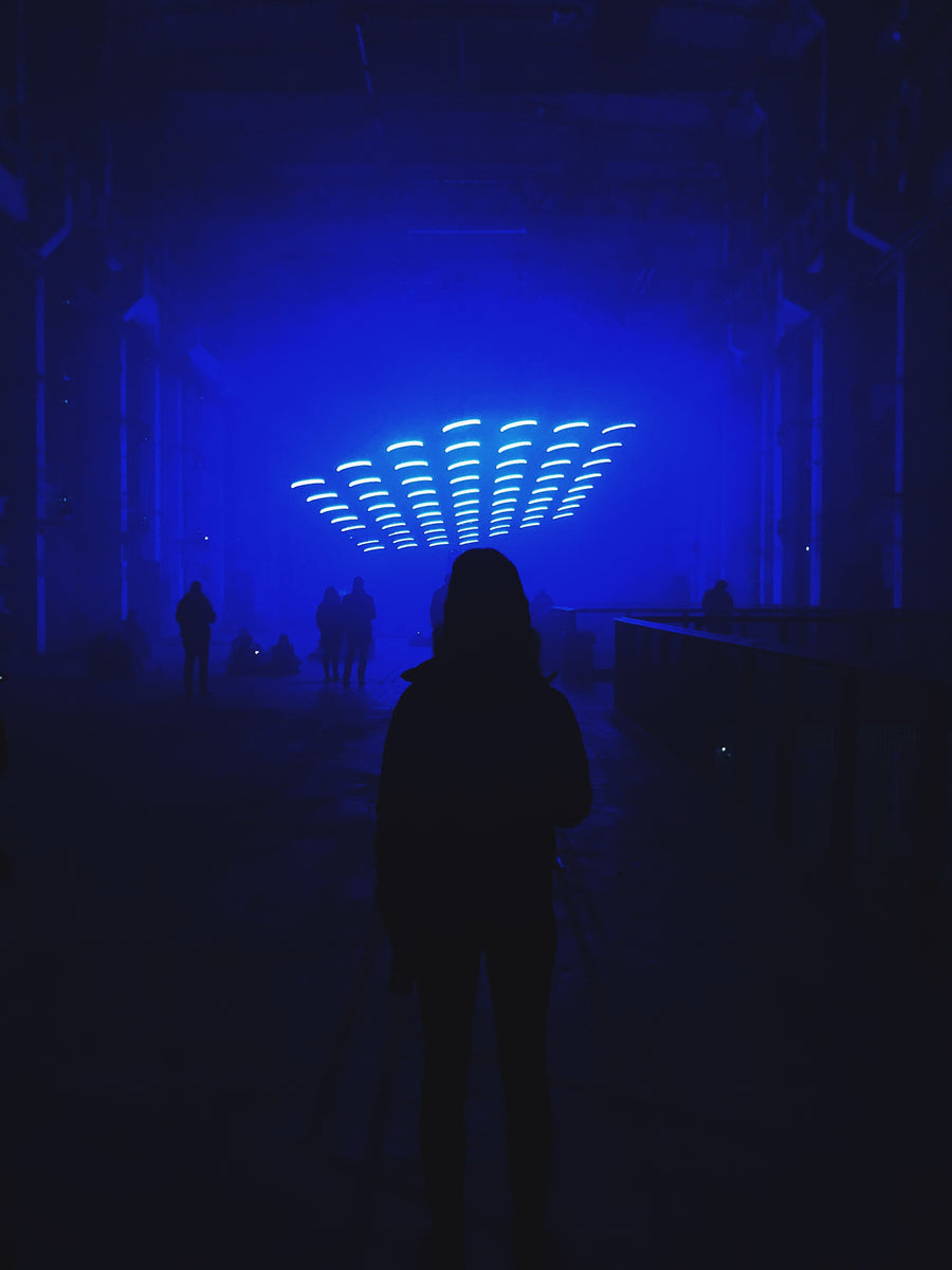 Person in einem blau beleuchteten Raum als Club-Stimmungsbild